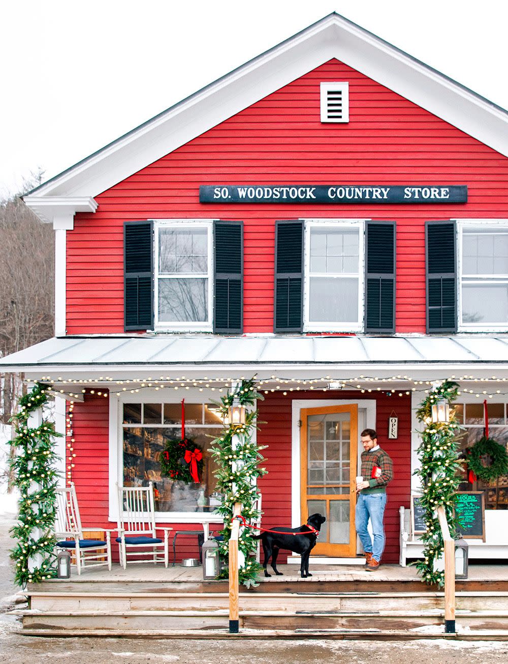 a person and a dog outside a general store in south woodstock vermont at christmas