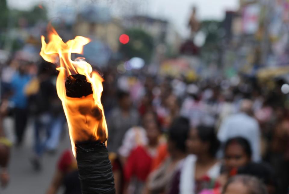 A protester holds torch as people march during a rally against rape and murder at RG Kar medical college (EPA)