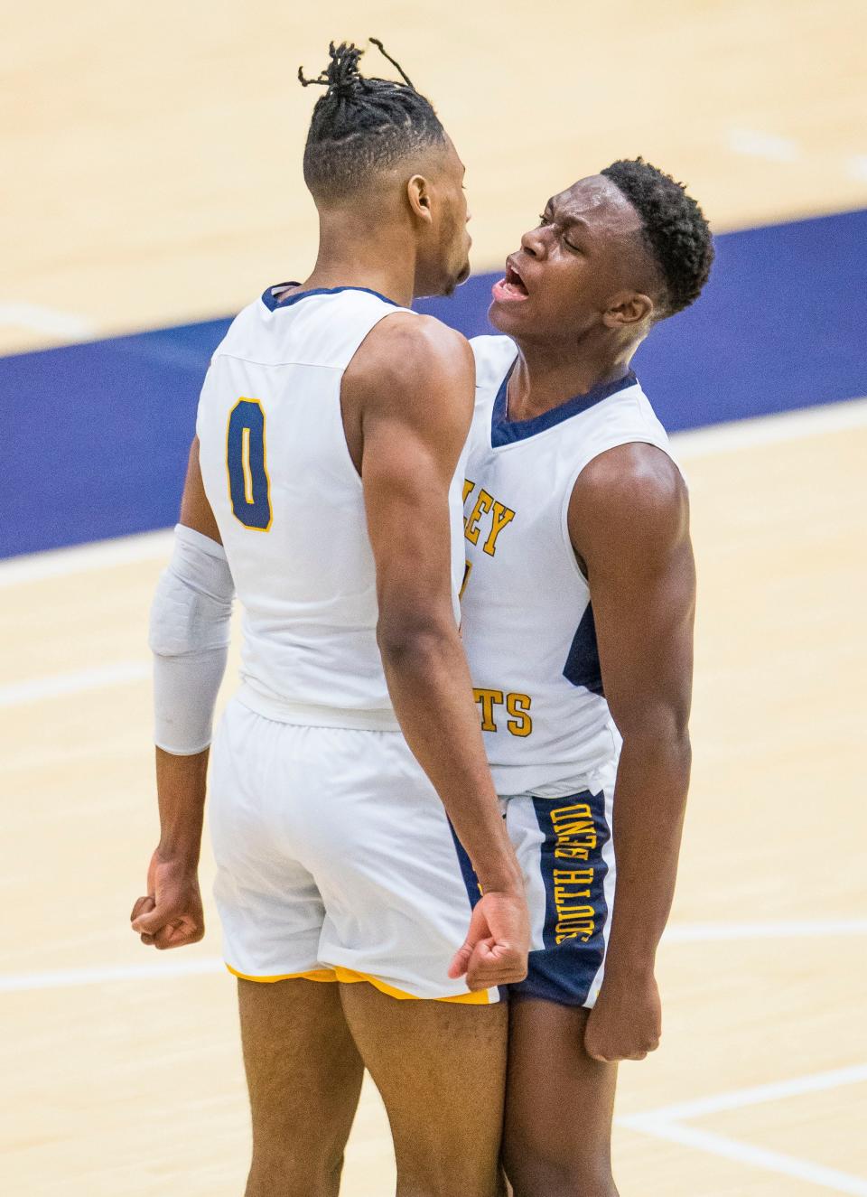 Riley’s Blake Wesley (0) and Isaiah Robinson (11) celebrate during the Riley vs. Valparaiso boys regional semifinal game Saturday, March 13, 2021 at Michigan City High School.
