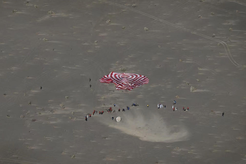 In this photo released by Xinhua News Agency, the capsule of Shenzhou-17 manned spaceship carrying astronauts Tang Hongbo, Tang Shengjie and Jiang Xinlin touches down at the Dongfeng landing site in north China's Inner Mongolia Autonomous Region, Tuesday, April 30, 2024. The return capsule of China's Shenzhou-17 manned spaceship landed back on Earth Tuesday with three astronauts who have completed a six-month mission aboard the country's orbiting space station. (Bei He/Xinhua via AP)