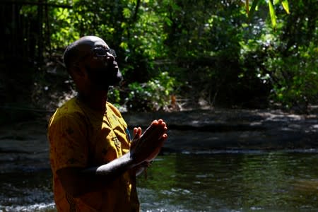 Lincoln Conner, says a prayer to his enslaved ancestors at the Assin Manso river