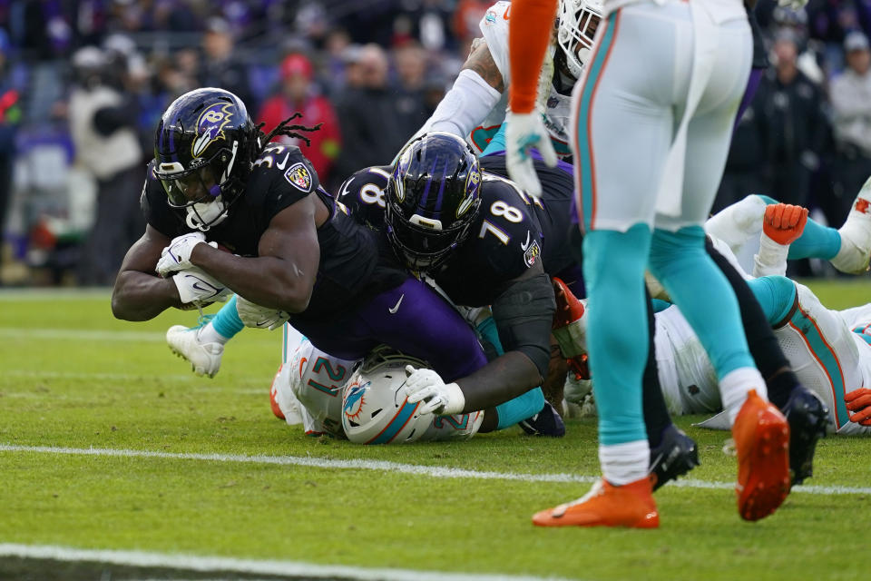 Baltimore Ravens running back Melvin Gordon III (33) runs for a touchdown against the Miami Dolphins during the second half of an NFL football game in Baltimore, Sunday, Dec. 31, 2023. (AP Photo/Matt Rourke)