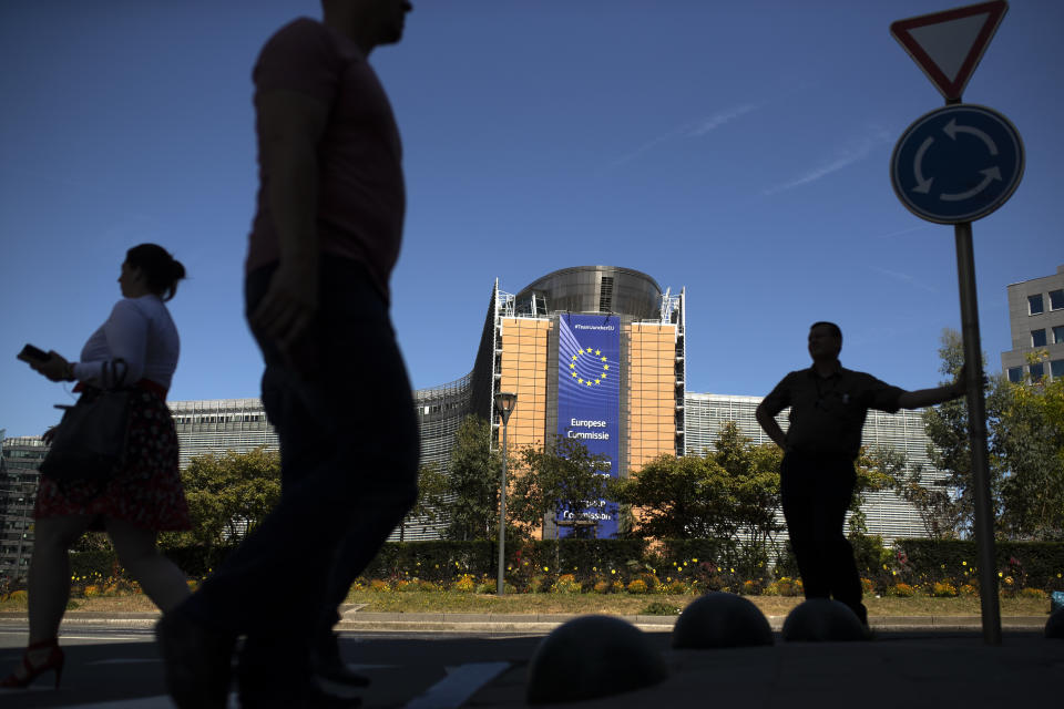 People walk past the European Commission headquarters in Brussels, Tuesday, July 23, 2019. Brexit champion Boris Johnson won the contest to lead Britain's governing Conservative Party on Tuesday and will become the country's next prime minister, tasked with fulfilling his promise to lead the U.K. out of the European Union. (AP Photo/Francisco Seco)