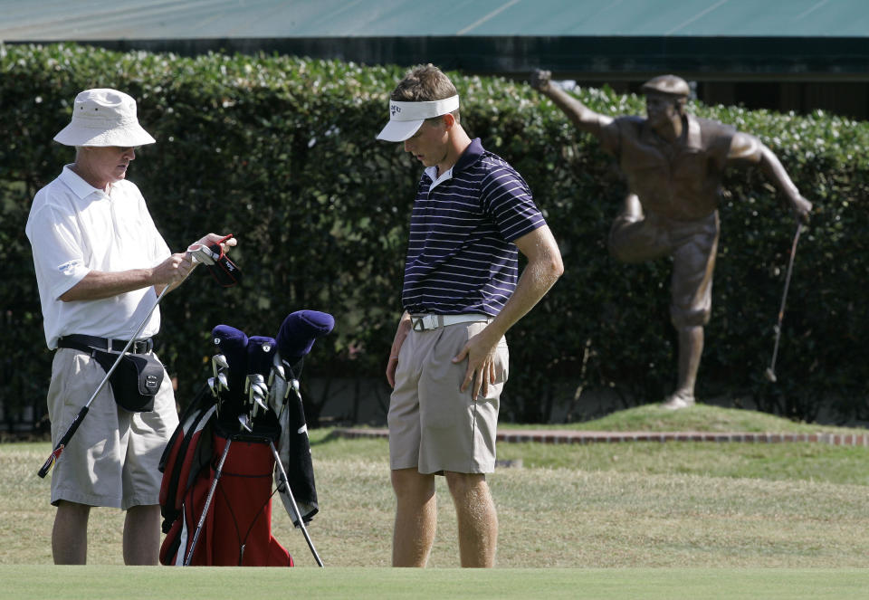 FILE - Caddie Mike Hicks, left, and Aaron Stewart, son of the late Payne Stewart, are seen on the 18th green at Pinehurst No. 2 in Pinehurst, N.C., on June 29, 2009, for the North & South Amateur. Payne Stewart won the 1999 U.S. Open at Pinehurst No. 2, four months before he perished in a plane crash. Aaron Stewart will be back at Pinehurst with his sister and mother for this year's U.S. Open to celebrate the 25-year anniversary of the 1999 U.S. Open. (AP Photo/Gerry Broome, File)