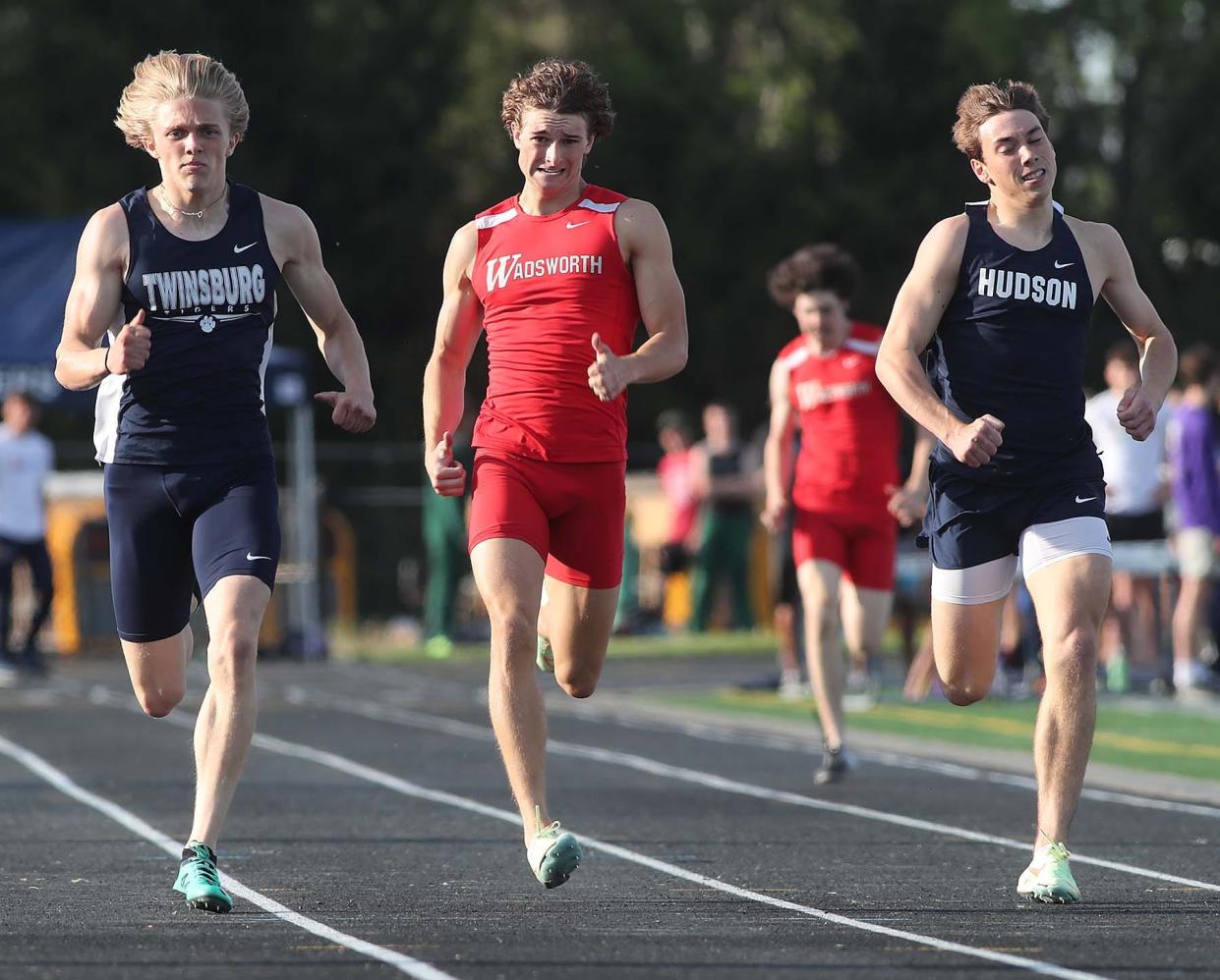 Logan Doyle, left, of Twinsburg, runs to a first place finish in the 400 meter dash with a time of 49.38 past Jackson Herbert, of Wadsworth placing second and Tyler Travis of Hudson placing third during the Suburban League National Conference track meet in Twinsburg on Thursday. 