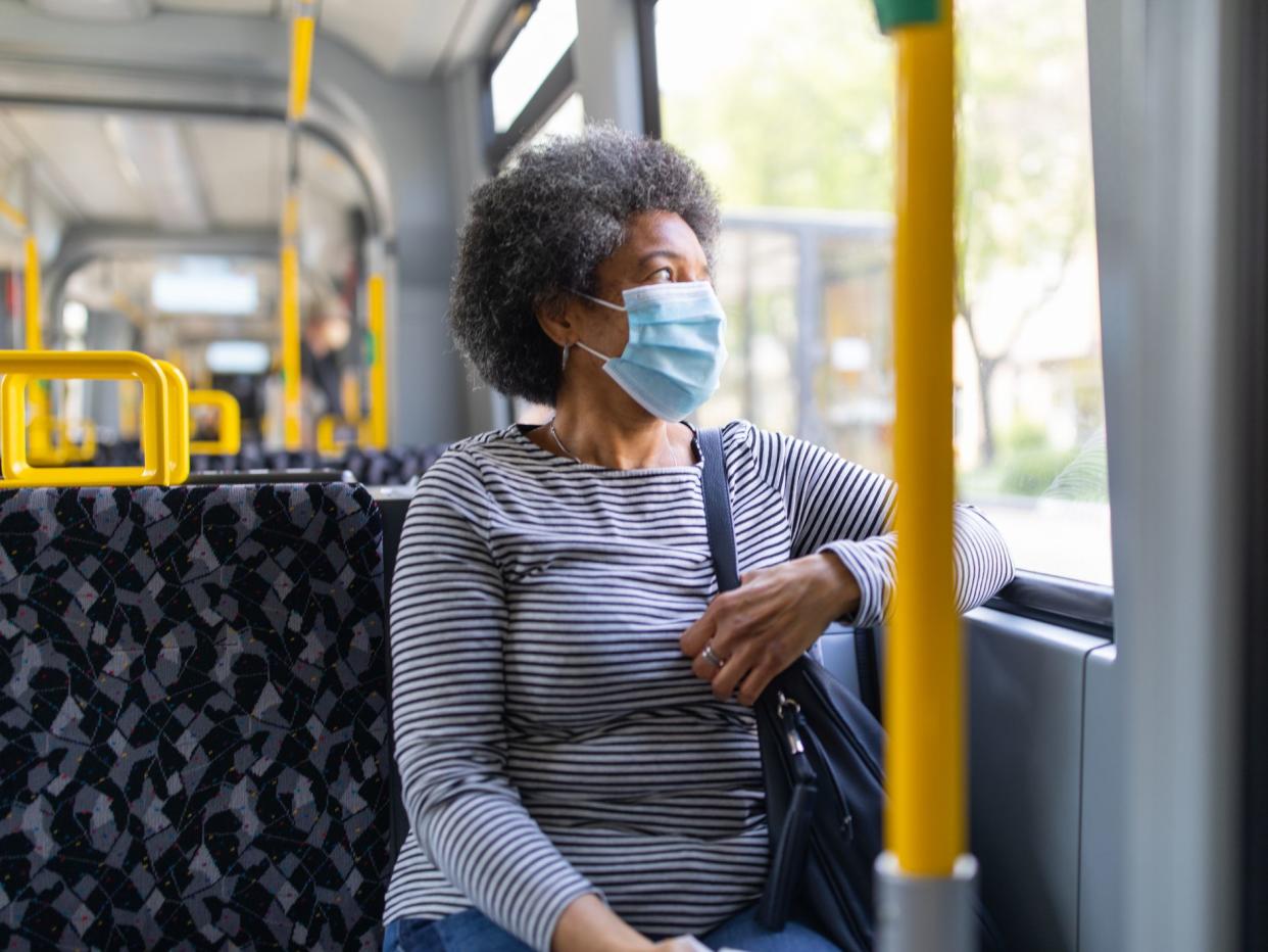 Woman wearing medical face mask commuting in a tram train during corona virus outbreak. Female travelling in metro during Covid-19 pandemic.