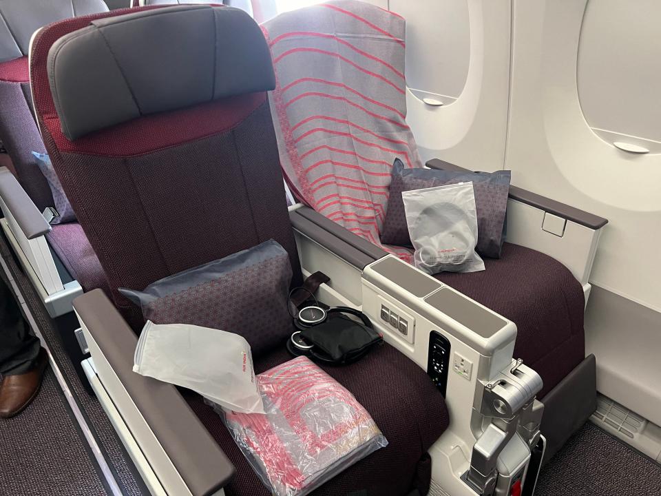 Air India premium economy with linens and headphones on the seat.