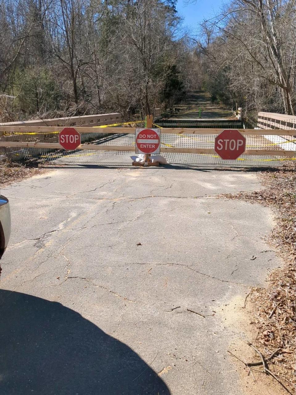 Stop signs warn pedestrians near the collapsed road bridge on Anne Springs Close Greenway property in Fort Mill.