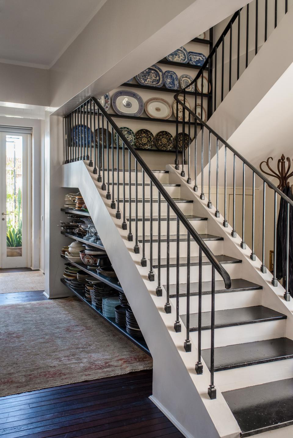 Broudo and Pollak use the space beneath and between the stairs to house their collection of dishes and servingware, found at antique markets all over England.