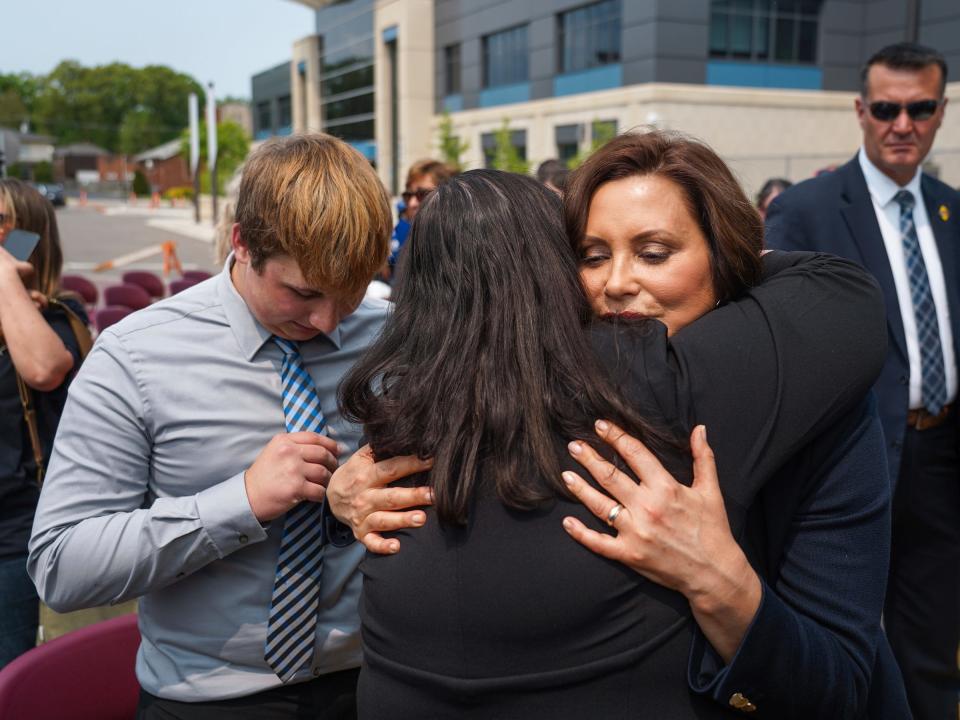 Michigan Governor Gretchen Whitmer is hugged by Linda Watson of Oxford May 22, 2023 as her son Oxford shooting survivor Aiden Watson stands by after Whitmer signed into law bills that would allow police officers, family members and medical professionals to ask courts to take away guns from those who pose a danger.