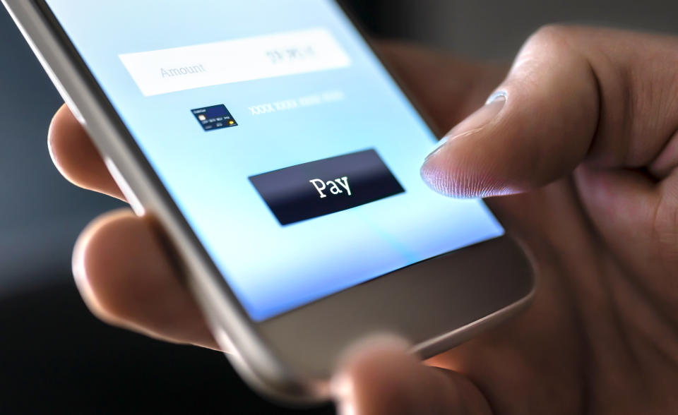 Mobile payment with wallet app and wireless nfc technology. Man paying and shopping with smartphone application and credit card information. Digital money transfer, banking and e commerce concept.