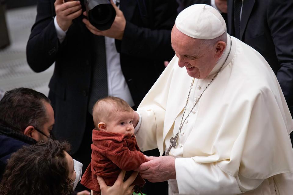 Pope Francis greets and blesses a baby during the traditional Wednesday General Audience in Paul VI Audience Hall.