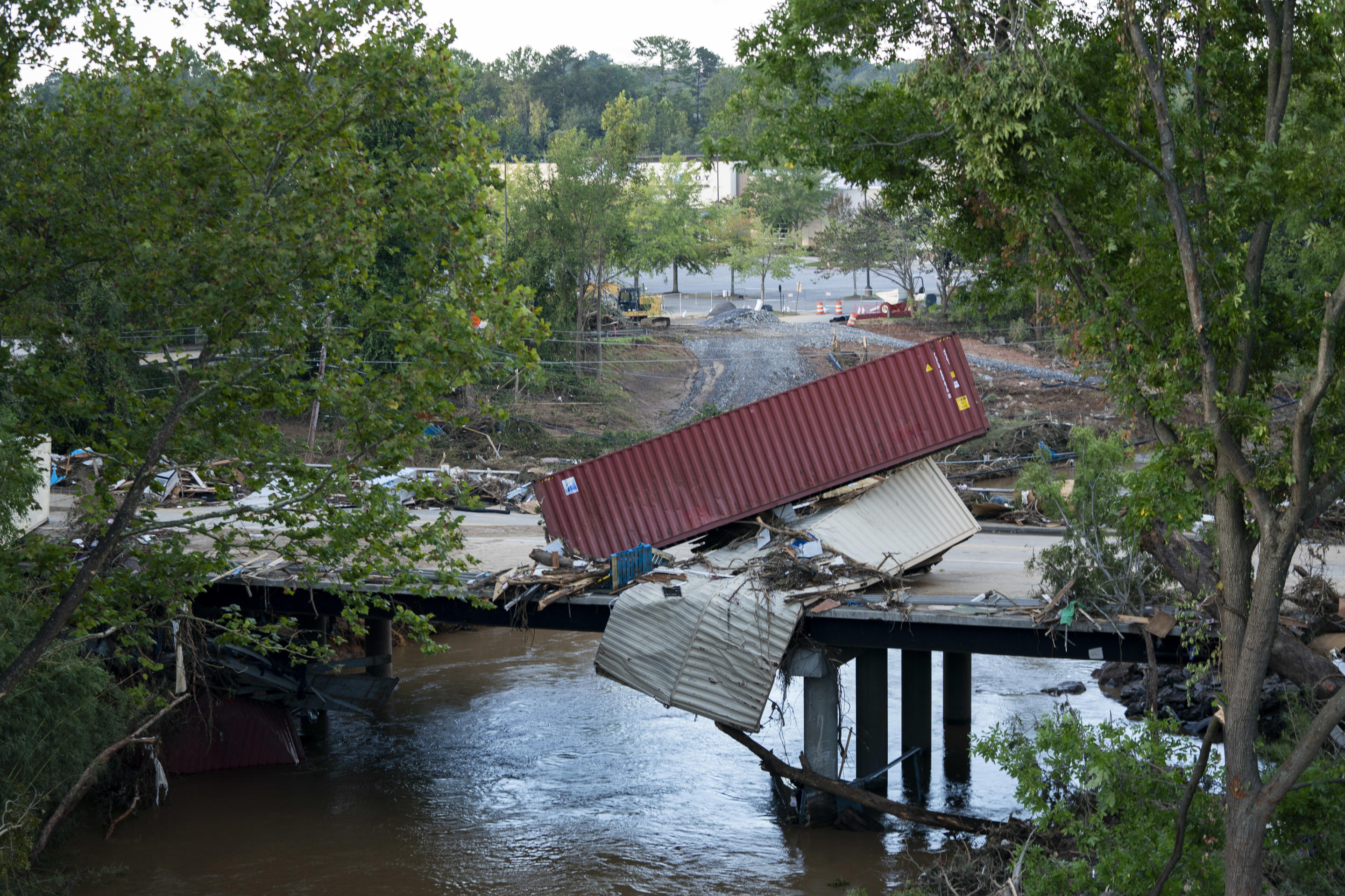 A large metal container and other debris are scattered on a street in Asheville, North Carolina 