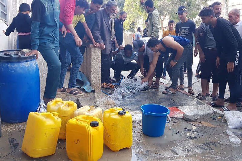 People extract water from an artesian well in Rafah refugee camp in the southern of Gaza Strip on Saturday as Israeli airstrikes continued. Photo by Ismael Mohamad/UPI