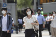 People wearing face masks to help protect against the spread of the new coronavirus pass on a crosswalk on a street in Tokyo, Tuesday, Aug, 4, 2020. (AP Photo/Koji Sasahara)
