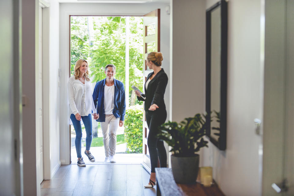 Real estate agent showing a young couple a new house.