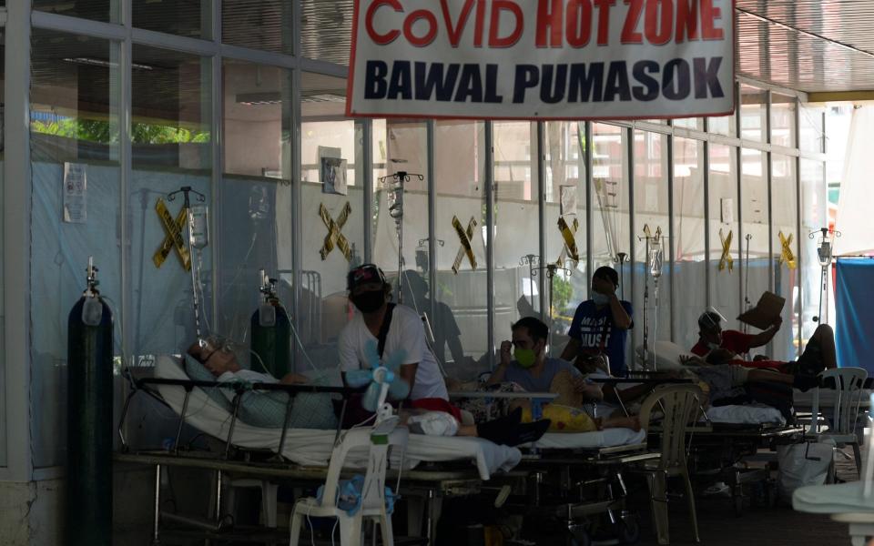 Suspected coronavirus patients lie on hospital beds outside the emergency room of Amang Rodriguez Memorial Medical Center, in Marikina City, Metro Manila - Reuters