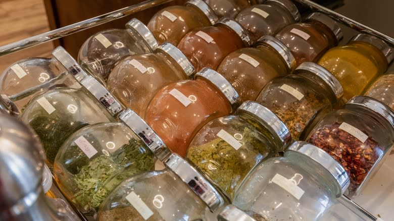 Drawer of spices displayed on glass jars