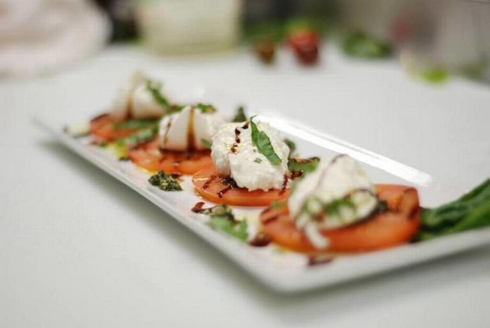 Carson's Caprese Salad is made with fresh seasonal tomatoes, burrata cheese, fresh basil pesto, balsamic reduction and olive oil.