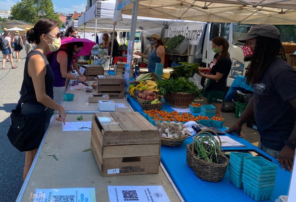 People shop in the Dupont circle farmers market wearing masks as a precution against COVID-19 in Washington, DC on July 26, 2020. (Photo by Daniel SLIM / AFP) (Photo by DANIEL SLIM/AFP via Getty Images)