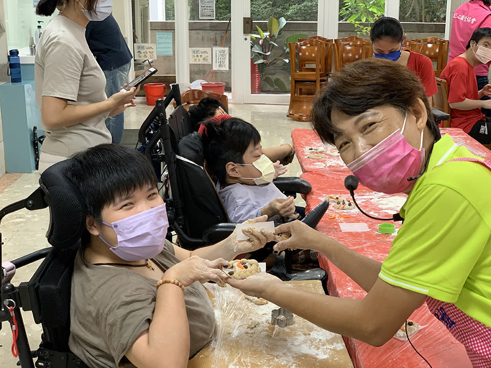 院生在饅頭上用葡萄乾和不同顏色的麵條作成笑臉。（新北市社會局提供）