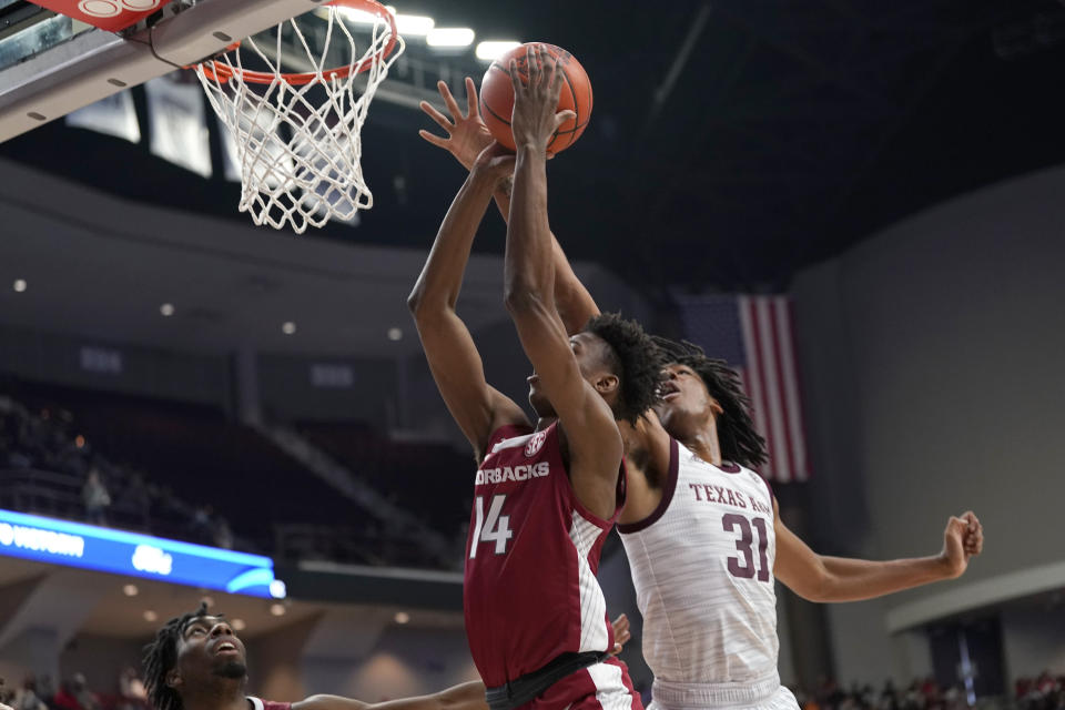 Texas A&M forward Javonte Brown (31) blocks a shot by Arkansas guard Jaxson Robinson (14) during the first half of an NCAA college basketball game Saturday, Jan. 8, 2022, in College Station, Texas. (AP Photo/Sam Craft)