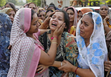 The daughter of Shantilal Boghra, who died in a cooking gas cylinder blast in Madhya Pradesh on Saturday, is consoled during the funeral of her father in Ahmedabad, September 13, 2015. REUTERS/Amit Dave