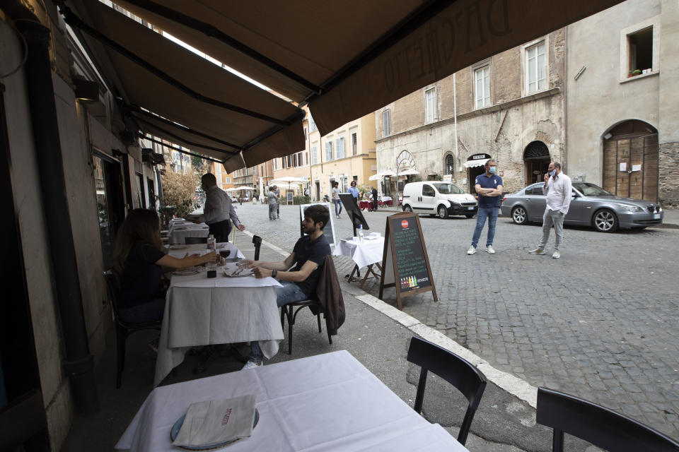 Customers have a lunch in a restaurant in downtown Rome, Monday, May 18, 2020 as Italy is slowly lifting sanitary restrictions after a two-month coronavirus lockdown. (AP Photo/Alessandra Tarantino)