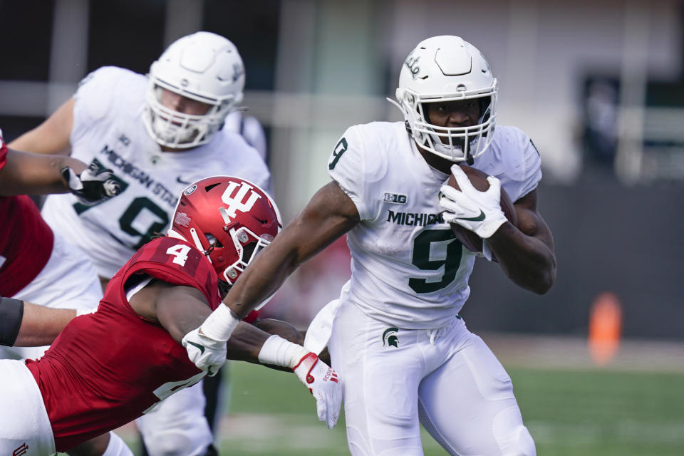 Michigan State's Kenneth Walker III (9) runs past Indiana's Cam Jones (4) during the second half of an NCAA college football game, Saturday, Oct. 16, 2021, in Bloomington, Ind. Michigan State won 20-15. (AP Photo/Darron Cummings)