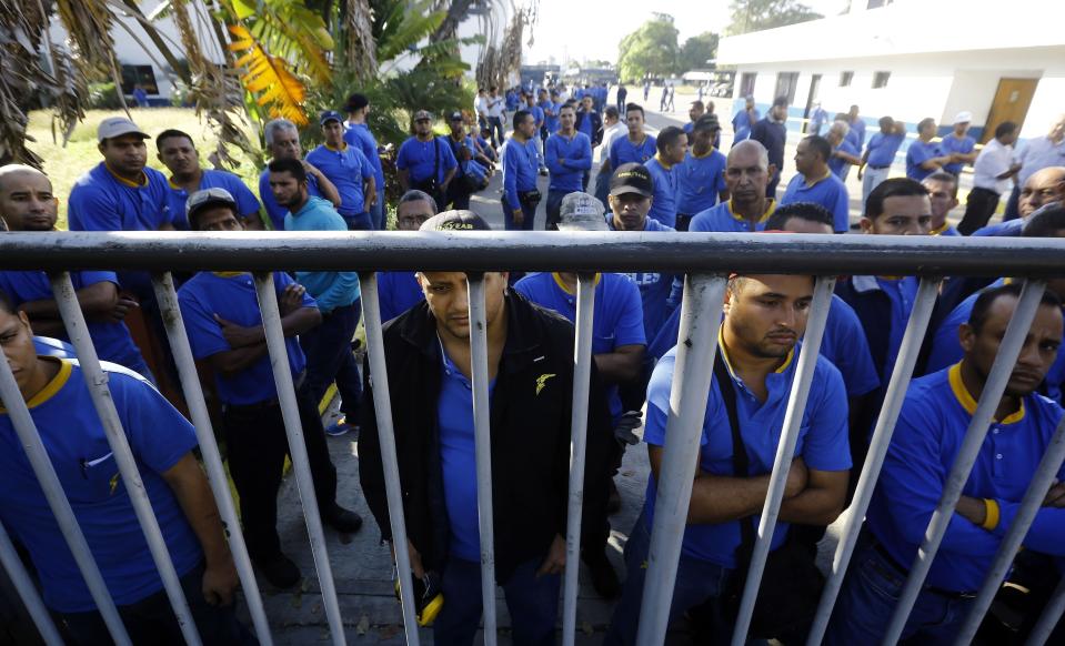 Trabajadores de Goodyear llegan a su sitio de labores para darse cuenta de que ya no opera en Los Guayabos, Venezuela, el lunes 10 de diciembre de 2018. (AP Foto/Juan Carlos Hernandez)