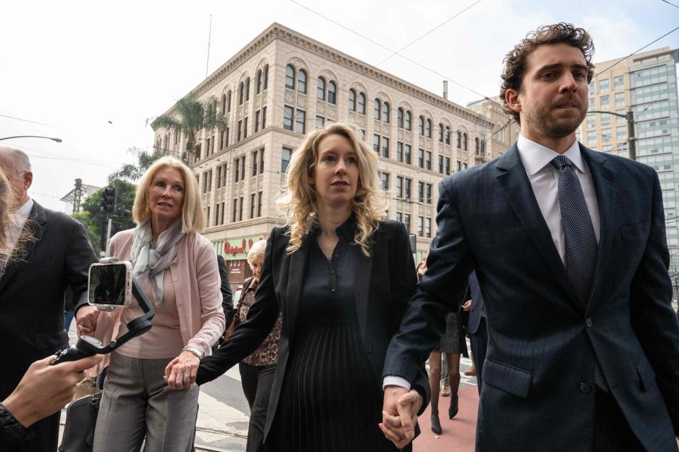 Elizabeth Holmes (C), founder and former CEO of blood testing and life sciences company Theranos, walks with her mother Noel Holmes and partner Billy Evans into the federal courthouse for her sentencing (AFP via Getty Images)