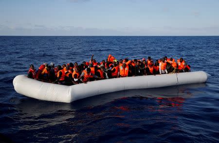 Migrants in a dinghy await rescue by the Migrant Offshore Aid Station (MOAS) around 20 nautical miles off the coast of Libya, June 23, 2016. Picture taken June 23, 2016. REUTERS/Darrin Zammit Lupi