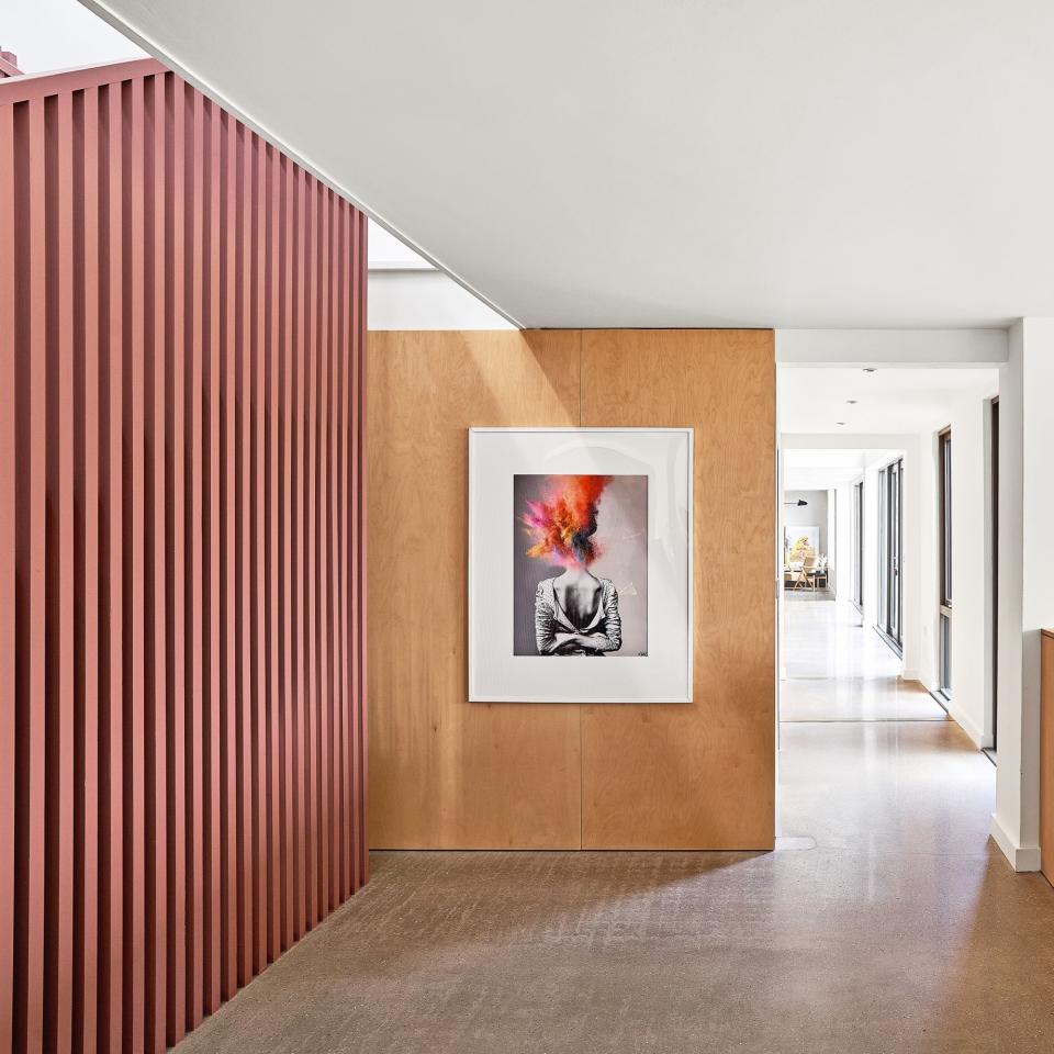 open landing space with pink wooden battens and artwork on walls