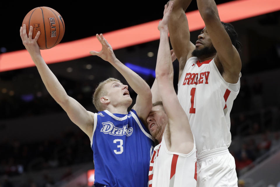 Drake's Garrett Sturtz (3) heads to the basket as Bradley's Nate Kennell and Ari Boya (1) defend during the second half of an NCAA college basketball game in the semifinal round of the Missouri Valley Conference men's tournament Saturday, March 7, 2020, in St. Louis. (AP Photo/Jeff Roberson)