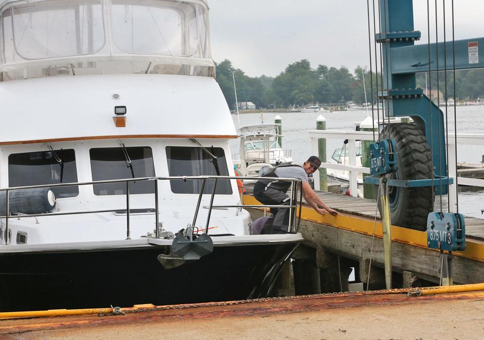 Workers at Great Bay Marine in Newington lift the boat Bay Dreamer from the water Wednesday, Sept. 13, 2023, in preparation for the potential impact of Hurricane Lee.