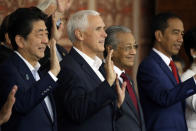 From left, Japanese Prime Minister Shinzo Abe, U.S. Vice President Mike Pence, Malaysian Prime Minister Mahathir Mohamad and Indonesia's President Joko "Jokowi" Widodo wave during a group photo at APEC Haus in Port Moresby, Papua New Guinea, Sunday, Nov. 18, 2018. (AP Photo/Mark Schiefelbein)