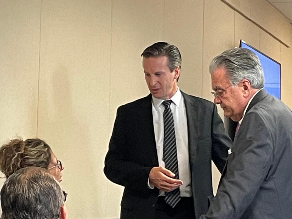 Assistant State Attorney Rich Buxman, wearing a tie, speaking with defense attorneys Daniel Hernandez and Debra Tuomey.