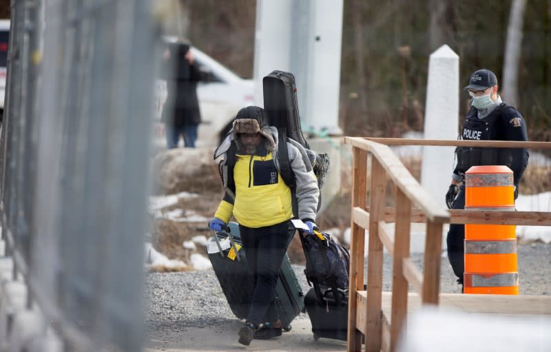 FILE PHOTO: An asylum seeker crosses the border from New York into Canada at Roxham Road in Hemmingford Quebec