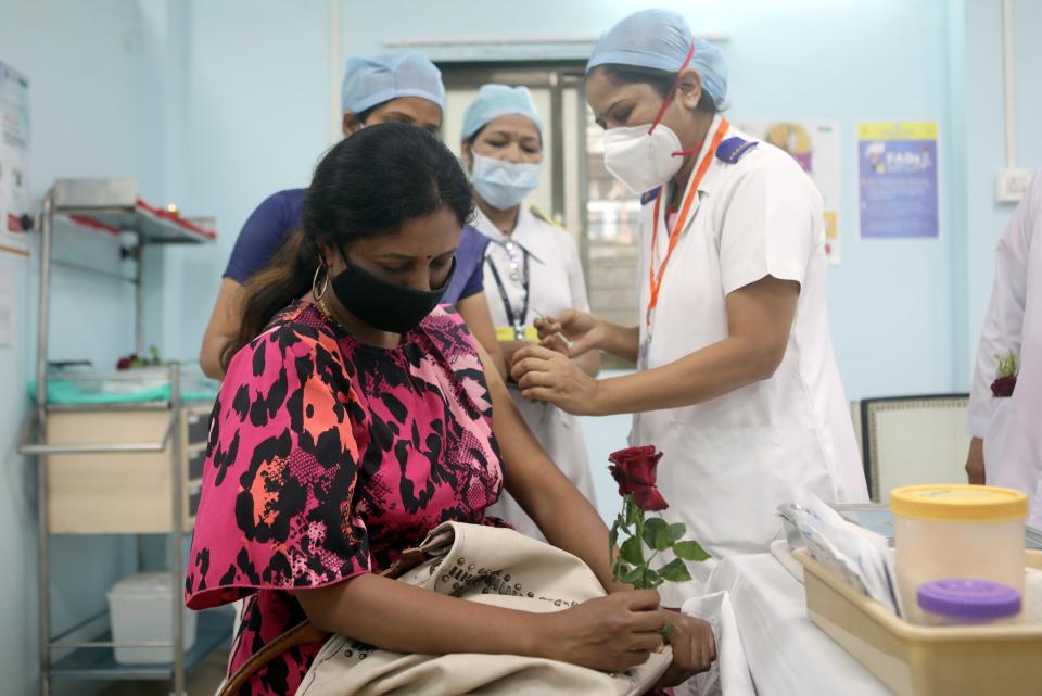 A healthcare worker holding a rose receives an AstraZeneca's COVISHIELD vaccine, during the coronavirus disease (COVID-19) vaccination campaign, at a medical centre in Mumbai, India, January 16, 2021.REUTERS