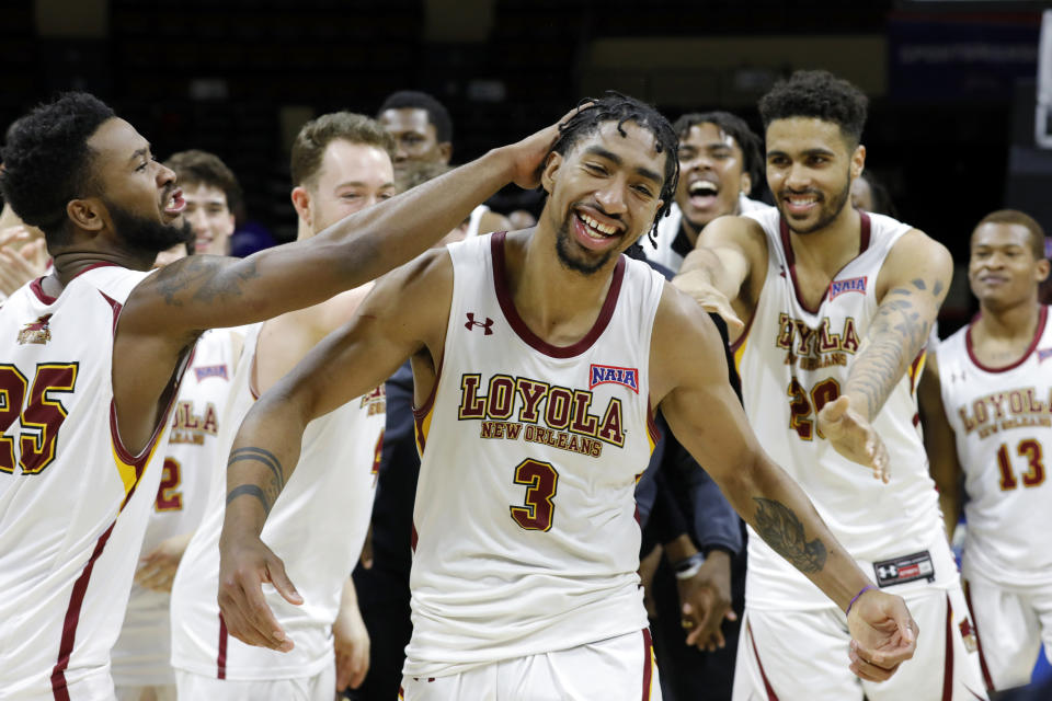 FILE - Loyola's (La.) Myles Burns (3) is congratulated by his teammates after he was named tournament MVP, as Loyola celebrates a 71-56 win against Talladega in the NAIA men's national championship college basketball game Tuesday, March 22, 2022, in Kansas City, Mo. Zach Wrightsil, Burns and Brandon Davis withstood the obstacles surrounding Hurricane Ida’s arrival in New Orleans last year and helped Loyola-New Orleans win the NAIA championship. Now the three of them are trying to make a jump rarely attended by going directly from an NAIA program to an NCAA Division I school. (AP Photo/Colin E. Braley)