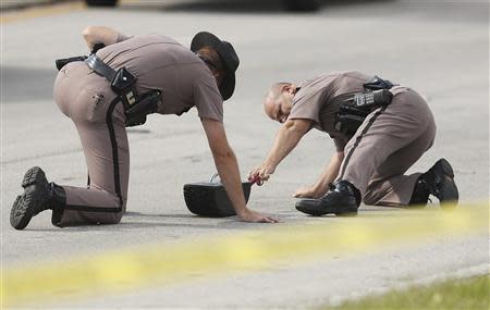 Highway Patrol officers investigate tire skid marks after several children were injured after being struck by a vehicle at a KinderCare Learning Center in Winter Park, Florida April 9, 2014. REUTERS/Stephen M. Dowell/Orlando Sentinel