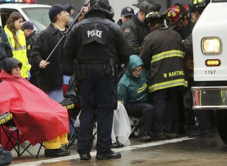 Emergency personnel use equipment to free a demonstrator blocking doors to the Oakland Police Department to protest against killings of unarmed black men by police officers in Oakland, California December 15, 2014. REUTERS/Robert Galbraith