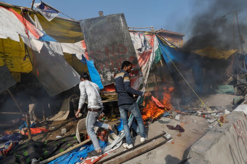 People supporting a new citizenship law destroy the protest site used by those opposing it, in New Delhi