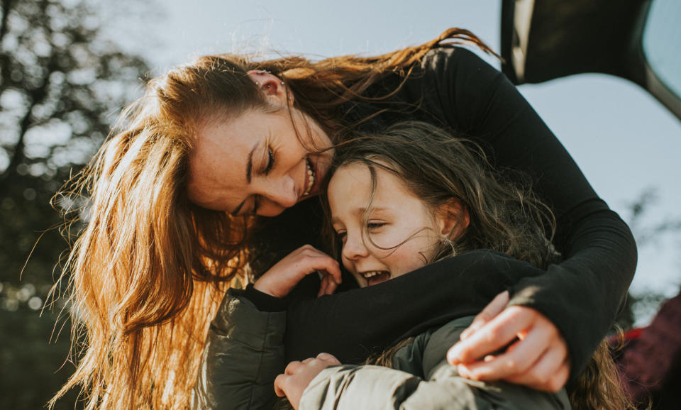 A woman hugging her daughter.