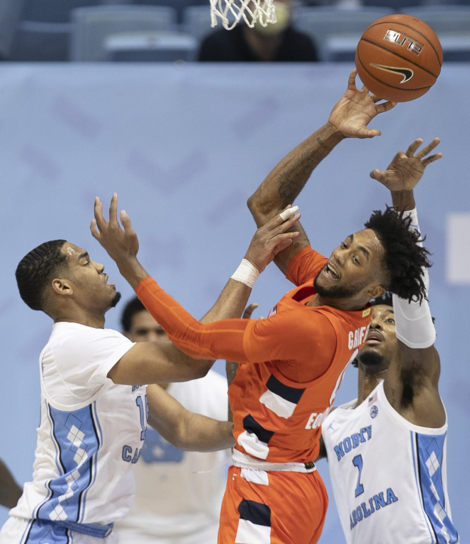 Syracuse's Alan Griffin (0) looks for an open teammate as he defended by North Carolina's Garrison Brooks (15) and Leaky Black (1) during the first half of an NCAA college basketball game Tuesday, Jan. 12, 2021, in Chapel Hill, NC. (Robert Willett/The News & Observer via AP)