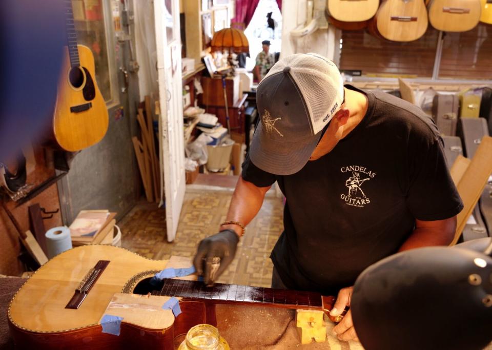 A man works on a guitar.