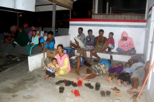 Residents gather outside their homes in Ternate after a strong magnitude 6,9 earthquake struck off Indonesia, triggering a brief tsunami warning that sent panicked residents fleeing to higher ground