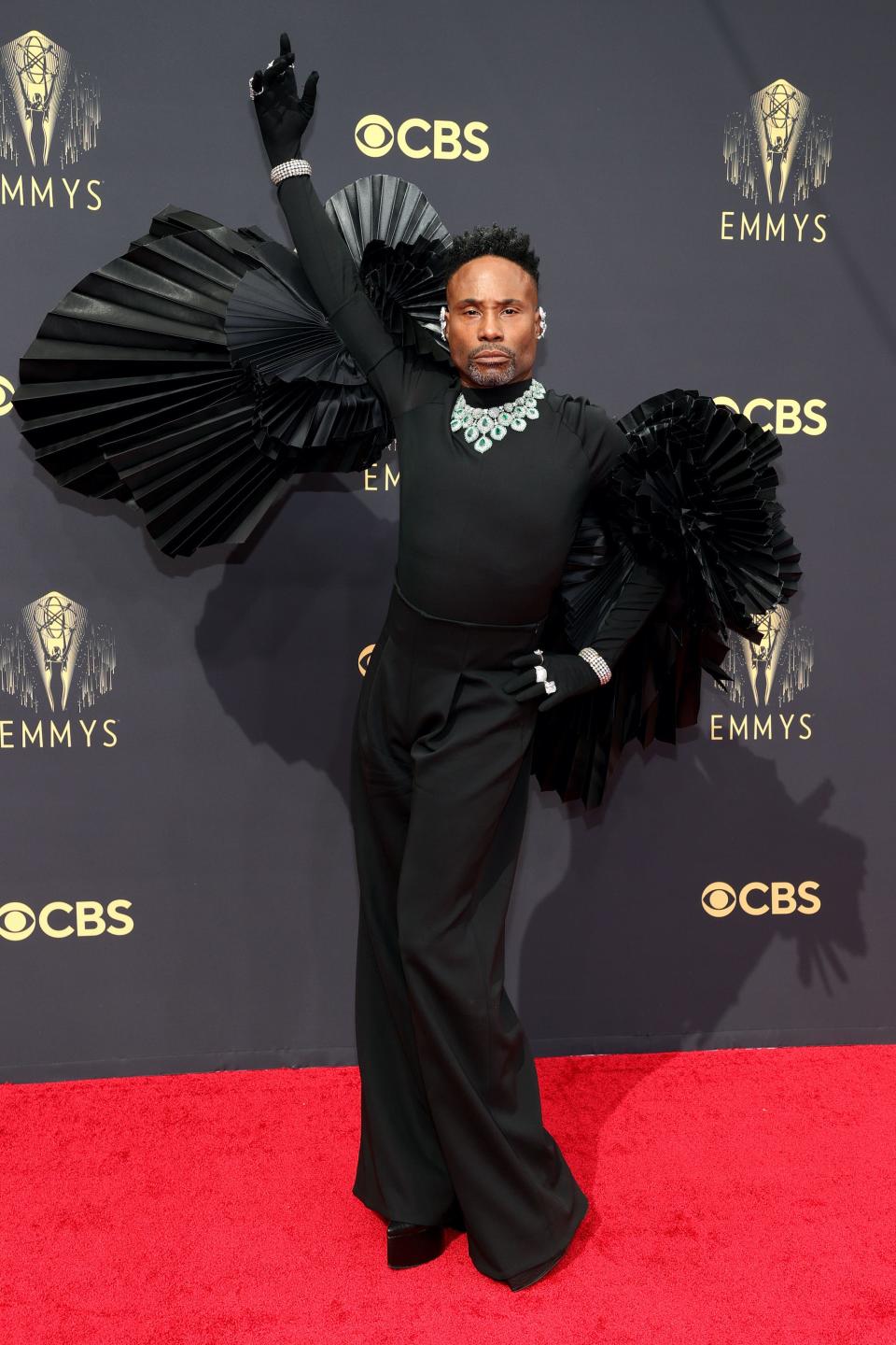 Billy Porter wears a black shirt, pants, and wings on the Emmys carpet.