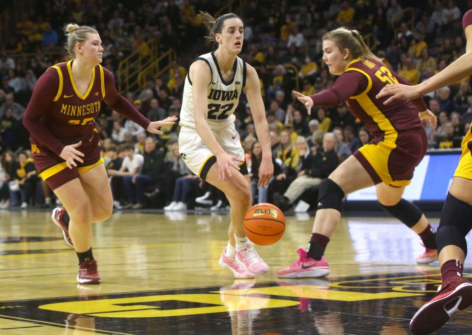 Iowa's Caitlin Clark (22) dribbles around the Minnesota defense Saturday, Dec. 30, 2023 at Carver-Hawkeye Arena.