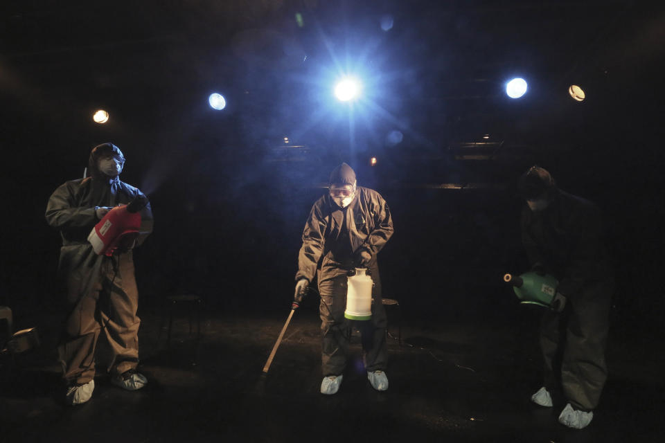 Trabajadores usan trajes protectores y cubrebocas al rociar desinfectante en las tareas de precaución contra un nuevo virus en un teatro en Seúl, Corea del Sur, el jueves 6 de febrero de 2020. (AP Foto/Ahn Young-joon)